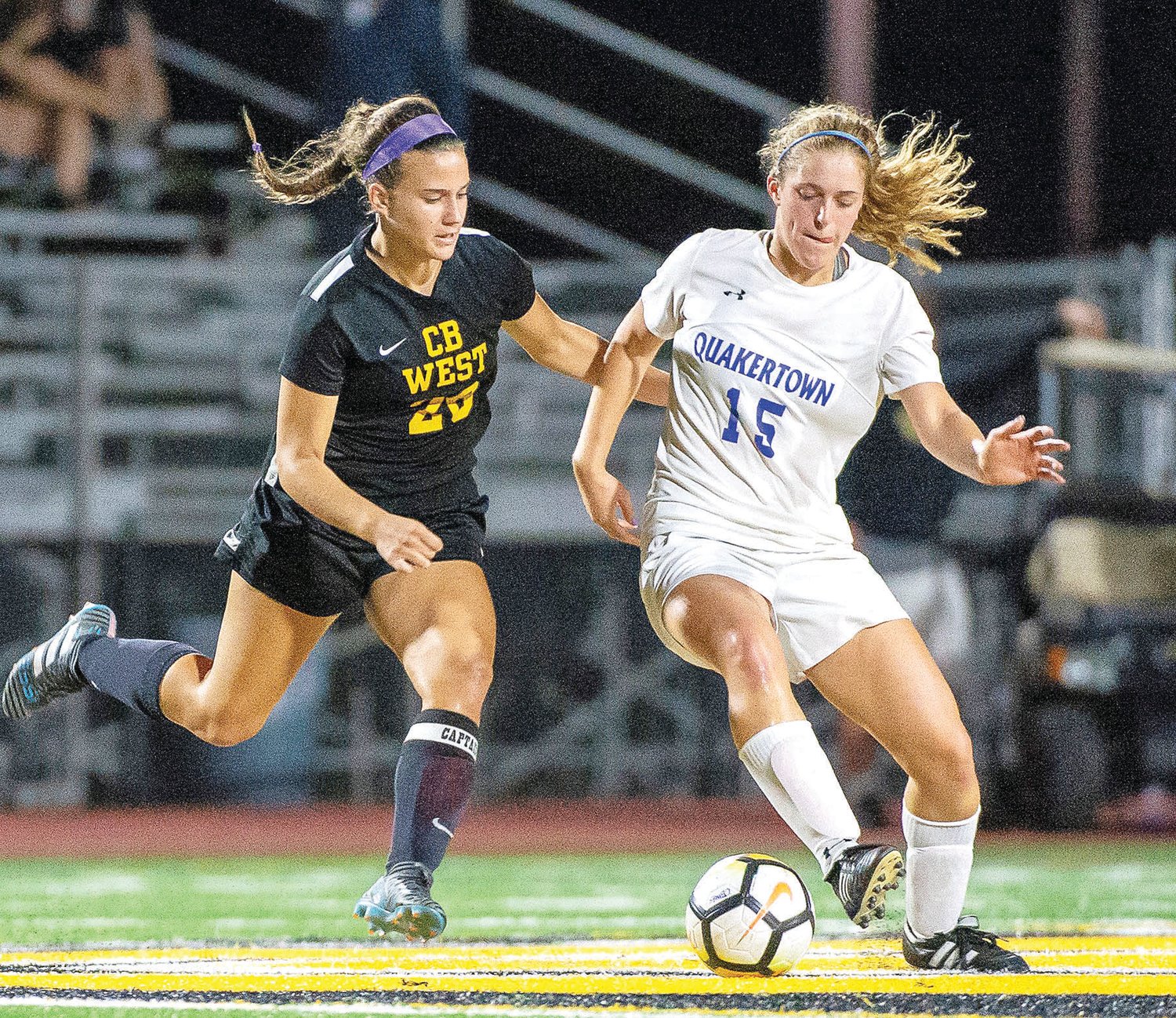 Central Bucks West senior Trish Hauck and Quakertown senior Haley Pursel, who has committed to play soccer at Lafayette next year, battle for the ball.  Photograph by Michael A. Apice