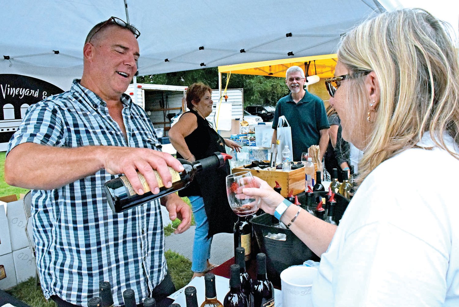 Kevin Bishop, co-owner of Bishop Winery, Hilltown, serves Donna Sitler of Blooming Glen. Photograph by Debby High