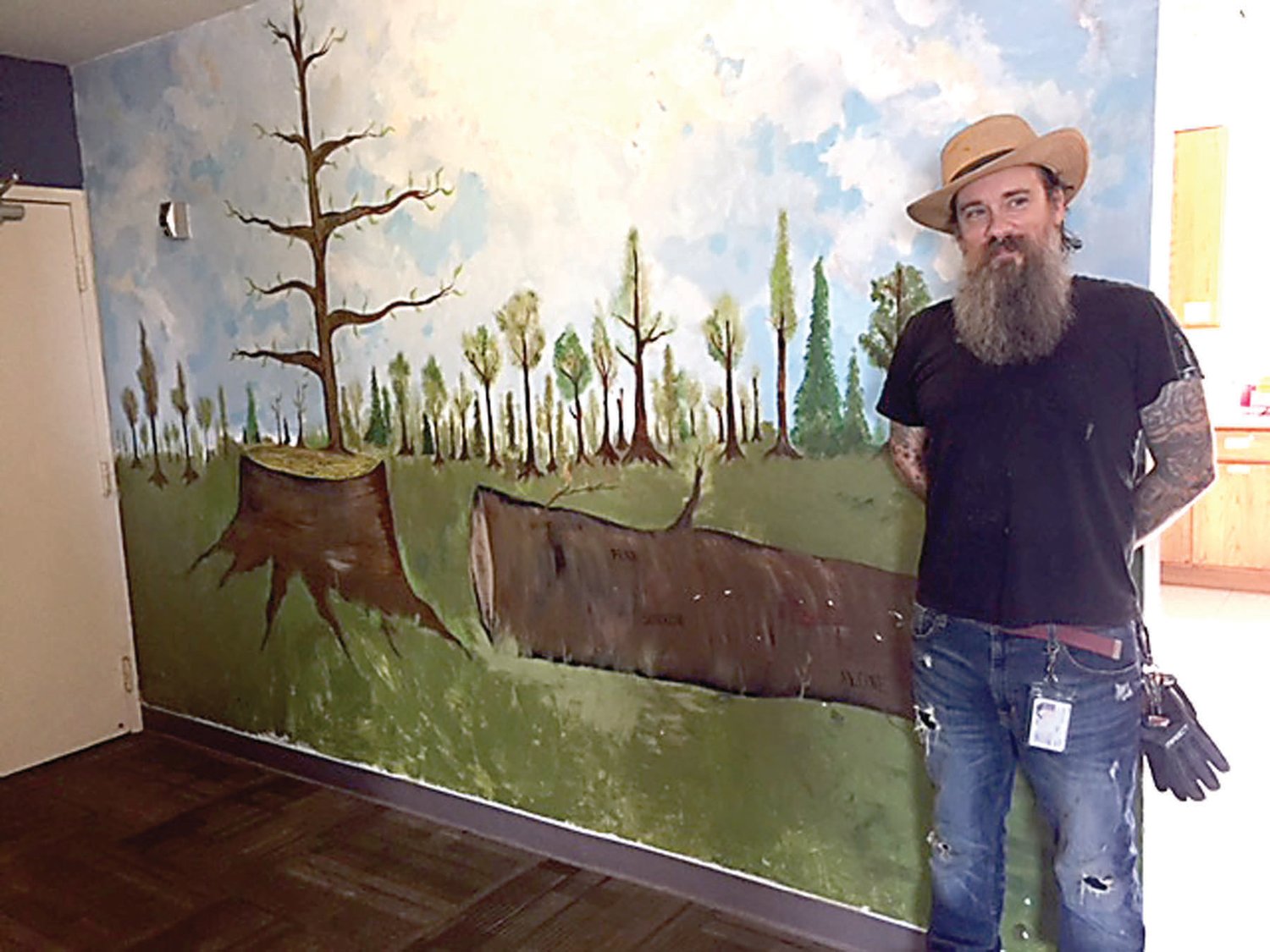 Rob Proffe, an outreach coordinator who is also an artist, helped perfect the mural symbolizing growth in the living room of Valley Youth House in Warminster.  The concept of the painting was developed by a group of teens living there. Photograph by Kathryn Finegan Clark