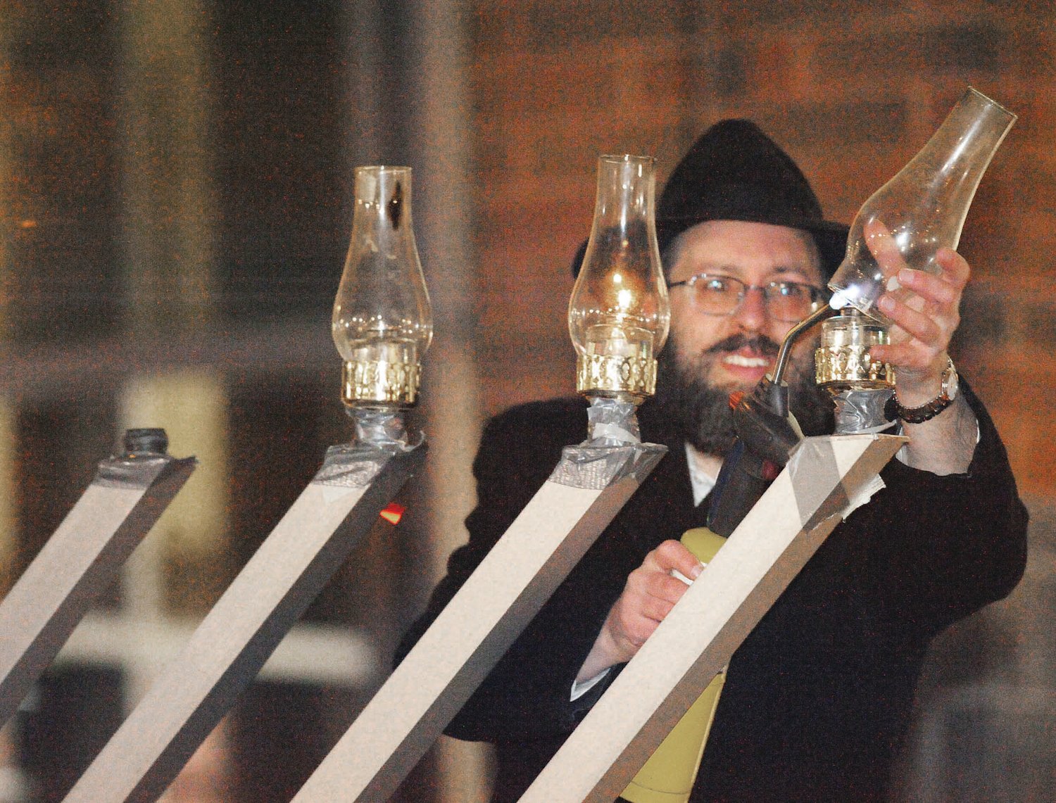 Rabbi Mendel Prus from Chabad Lubavitch of Doylestown lights the Hanukkah menorah in front of the courthouse in Doylestown. Photograph by Tom Shewbrooks.