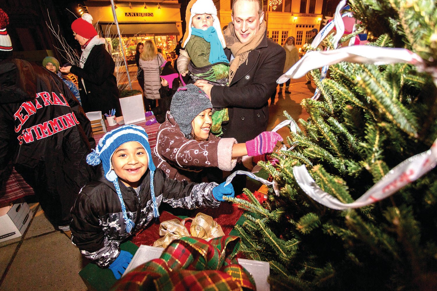 Young visitors to Flemington, N.J., place a ribbon on the Wishing Tree. Wishes can be placed on the tree again Dec. 20, during this year’s Thursday Night Holiday Lights.