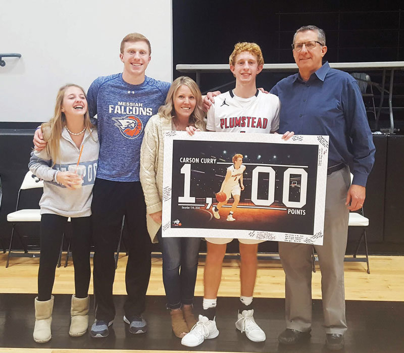 Surrounded by his family, Carson Curry holds up a poster commemorating his 1,000th career point.  Photograph courtesy of Plumstead Christian School