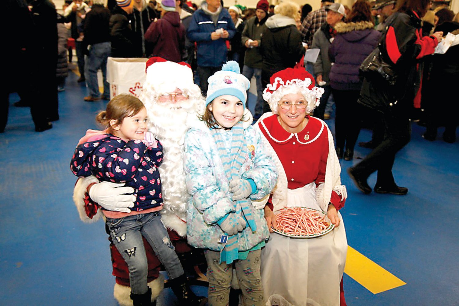 Marni Rambo and Kaylee Alles are delighted to visit with Santa and Mrs. Claus.  Photograph by Chris Ruvo.