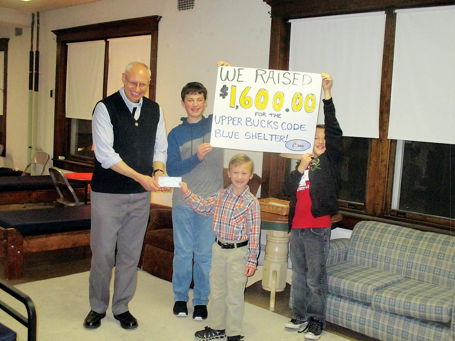 Eight-year-old Caleb Byelich presents the proceeds of his cocoa stand to David Heckler of the Upper Bucks Code Blue Homeless Shelter. Caleb’s brothers, Cameron, 15, and Jaiden, 12, helped him present the check.