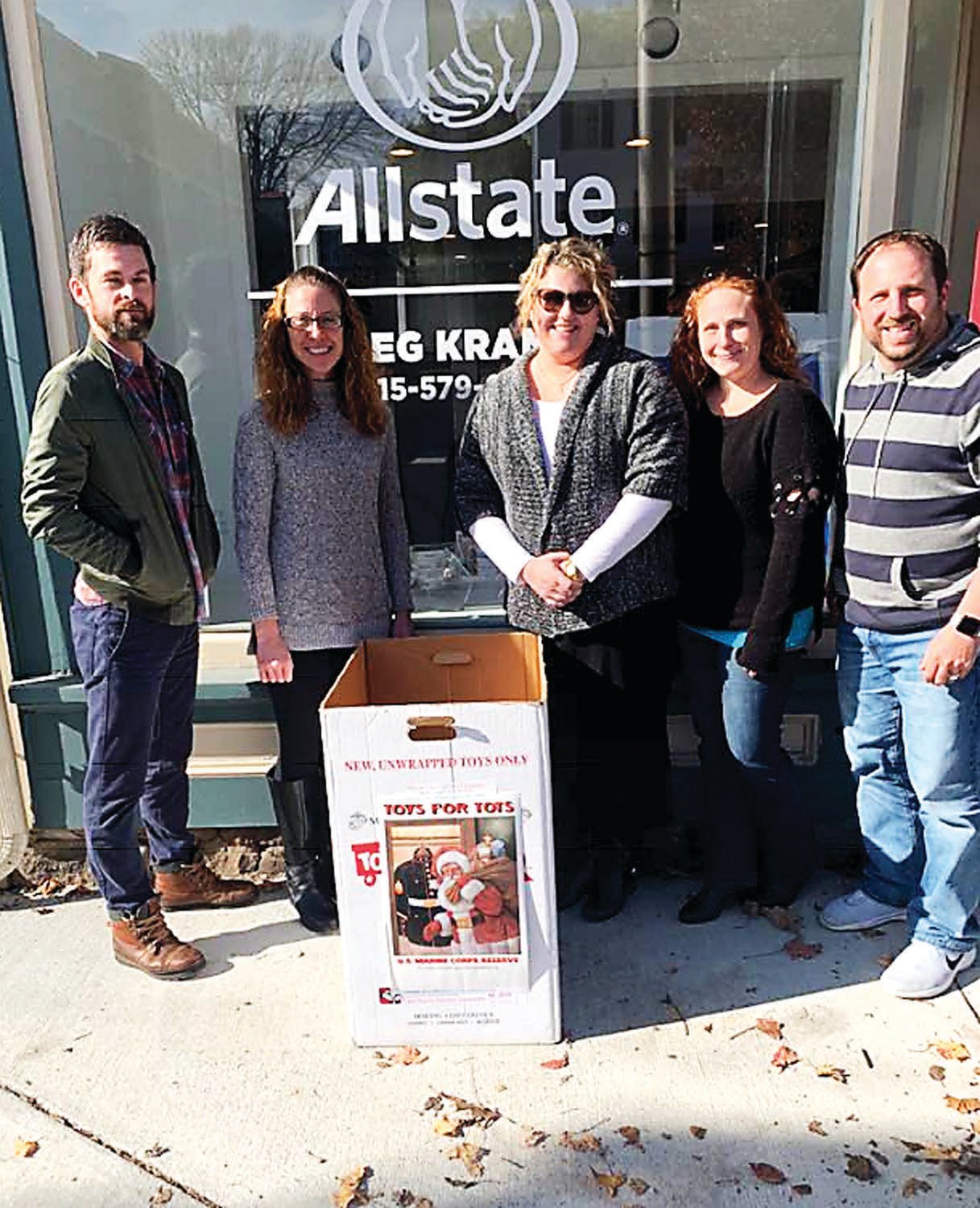 Greg Kramer and his team stand in front of his Allstate agency in Newtown with their Toys for Tots donation box.