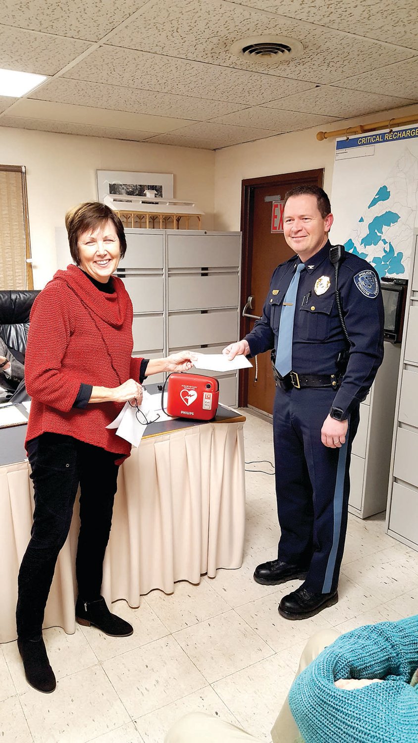 Sue Walsh, president of the Tinicum Civic Association, presented a donation of $1,000 to Tinicum Police Chief Matt Phelan, receiving on behalf of the Tinicum Township Police Foundation, for the purchase of an automated external defibrillator (A.E.D.) for the township police department. Photograph by Cliff Lebowitz