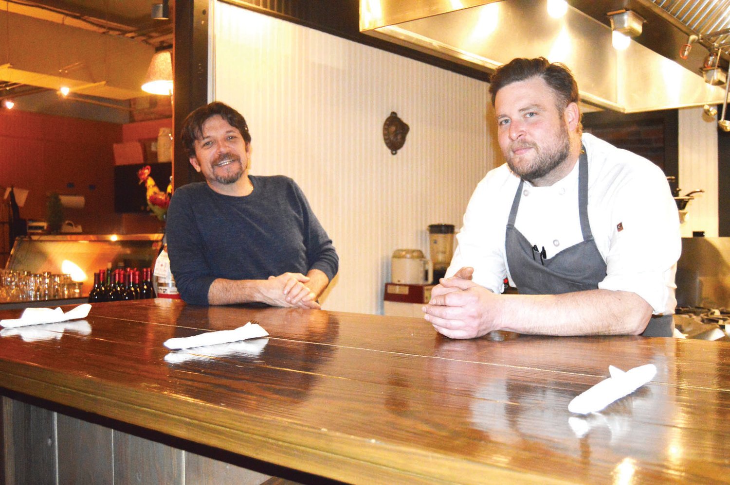 Owner Andre Jurema, left and chef Justin McLain, stand at the new chef’s table at Andre’s Wine & Cheese Shop in Doylestown. The shop has transitioned to a full-service restaurant. Photograph by Susan S. Yeske