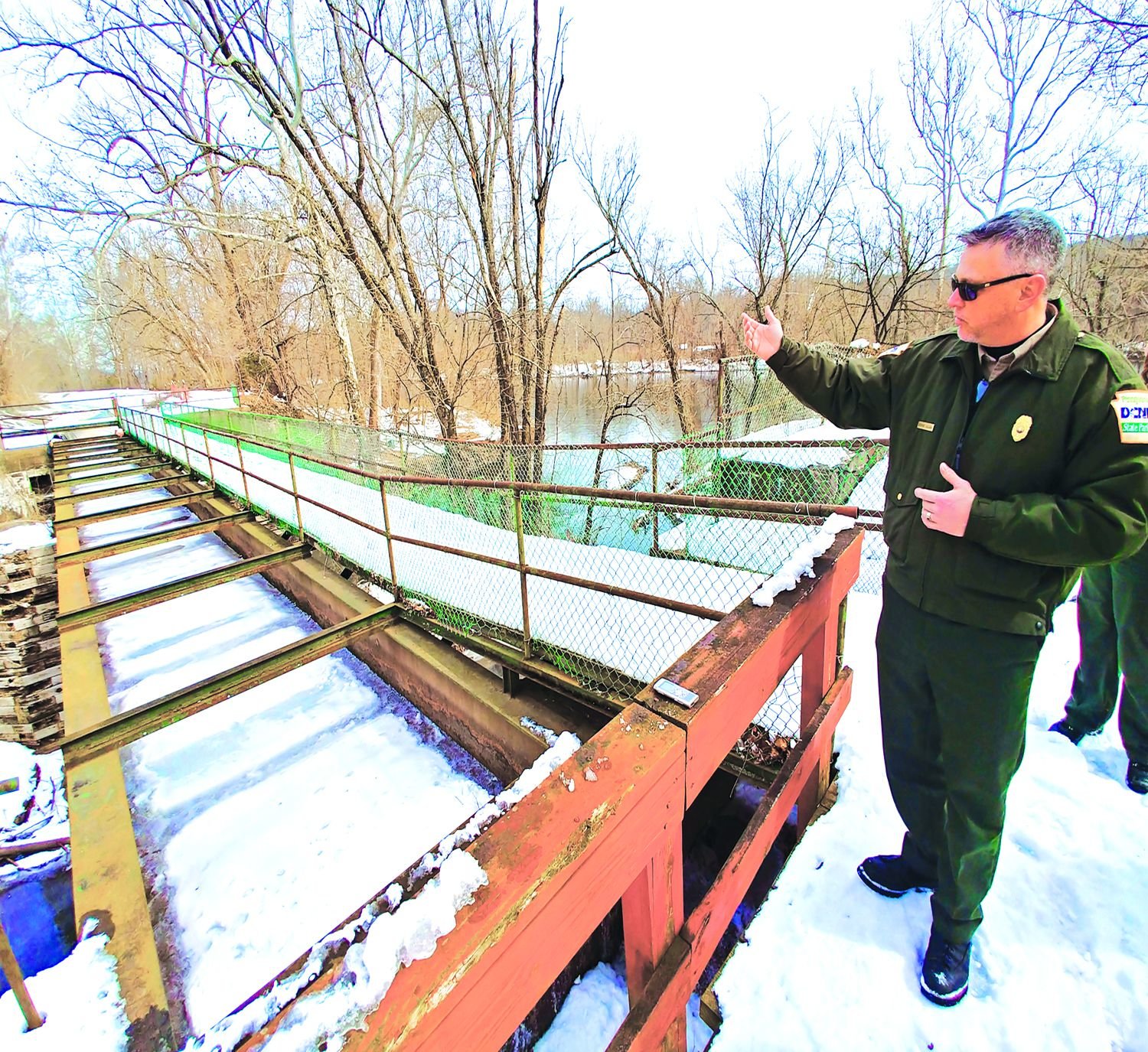 DCNR State Park Manager George Calaba describes needed repairs to the Tinicum Aqueduct in Delaware Canal State Park. The park is one of the sites target for improvements as part of a proposed four-year, $4.5 billion infrastructure project by the Wolf administration called Restore Pennsylvania. State officials toured the canal March 8. Photograph by Stuart Lee Friedman.