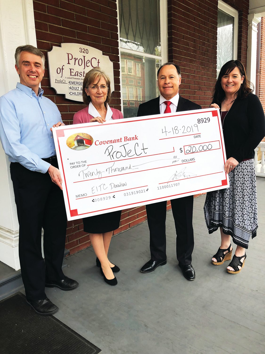 In front of the ProJeCt of Easton administration building, from left, Tom Harper, director of development at ProJeCt, and Janice Komisor, chief executive officer, accept a $20,000 EITC donation from Blair T. Rush, chief operating officer of Covenant Bank; and Eileen Wass, vice president of human resources and marketing.