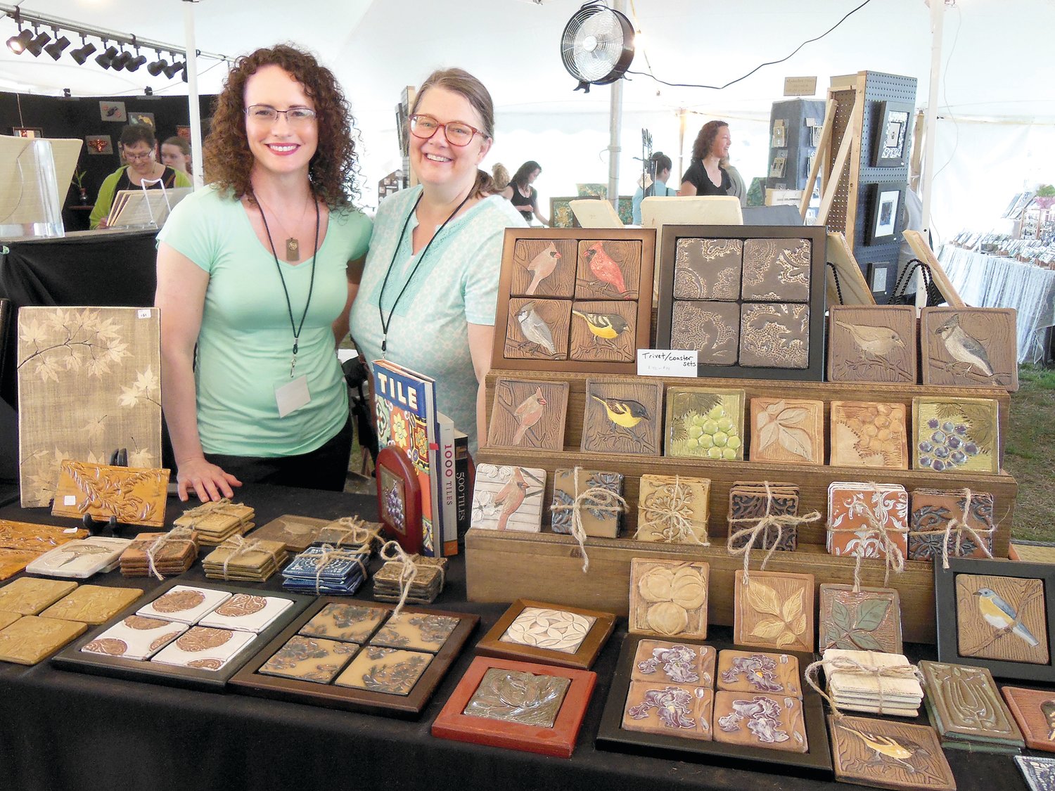 Tile artisan Theresa Mustafa of Boonton, N.J., left, will be among the participants in the 21st annual Tile Festival at the Moravian Pottery and Tile Works in Doylestown.  Admiring Mustafa’s creative work is Jen Stein, also a tile maker, of Ramsey, N.J.