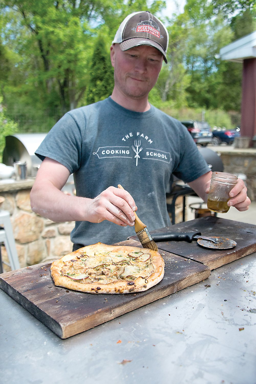 Ian Knauer, co-founder of the Farm Cooking School, creates a potato and dill pizza. Photograph by Chiara Chandoha.