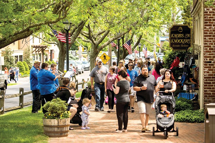 People enjoying live music and sidewalk sales at last year’s Peach Festival.