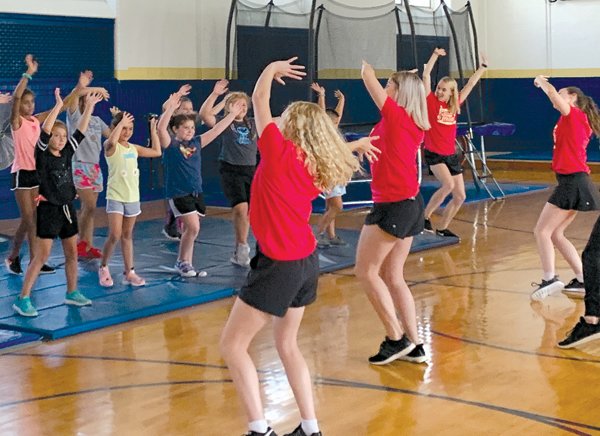 The cast of “Mamma Mia!” teach a dance routine to summer campers.