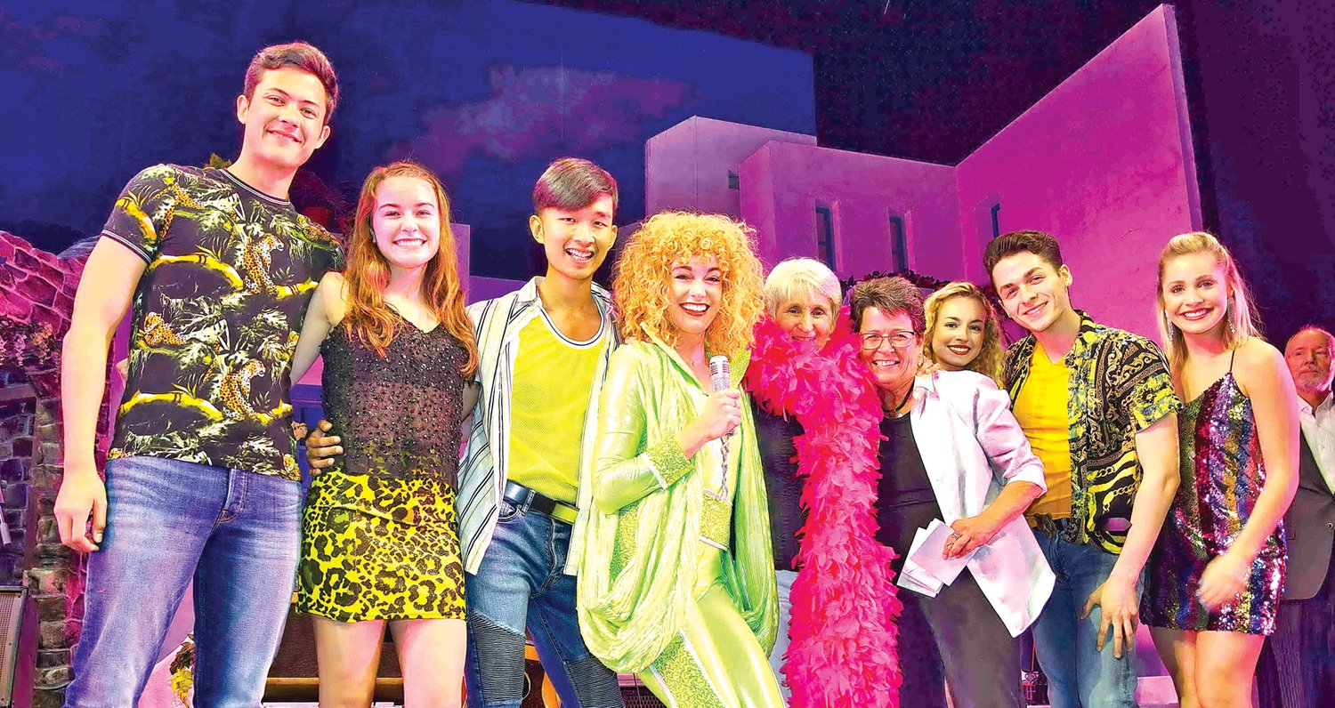 Bucks County Playhouse interns surprise Geri Delevich, center, with a performance of “Dancing Queen” from the theater’s current production of “Momma Mia!” Photograph by Gordon and Libby Nieburg.