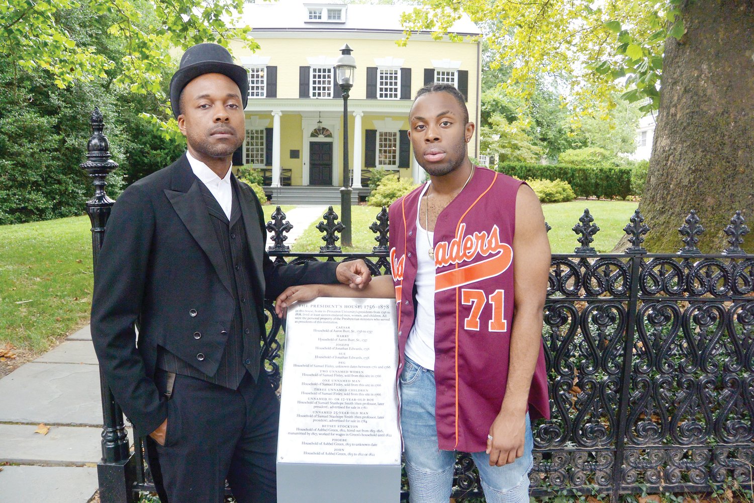 Topdog/Underdog cast members Travis Raeburn and Nathaniel Ryan stand in front of Maclean House at Princeton University, with a memorial to the 16 enslaved individuals who occupied the building when it served as the official residence of the university president.