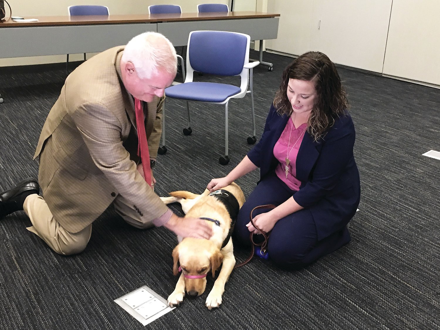 District Attorney Matthew Weintraub pets Daisey, the justice office’s comfort dog. Photograph by Freda R. Savana
