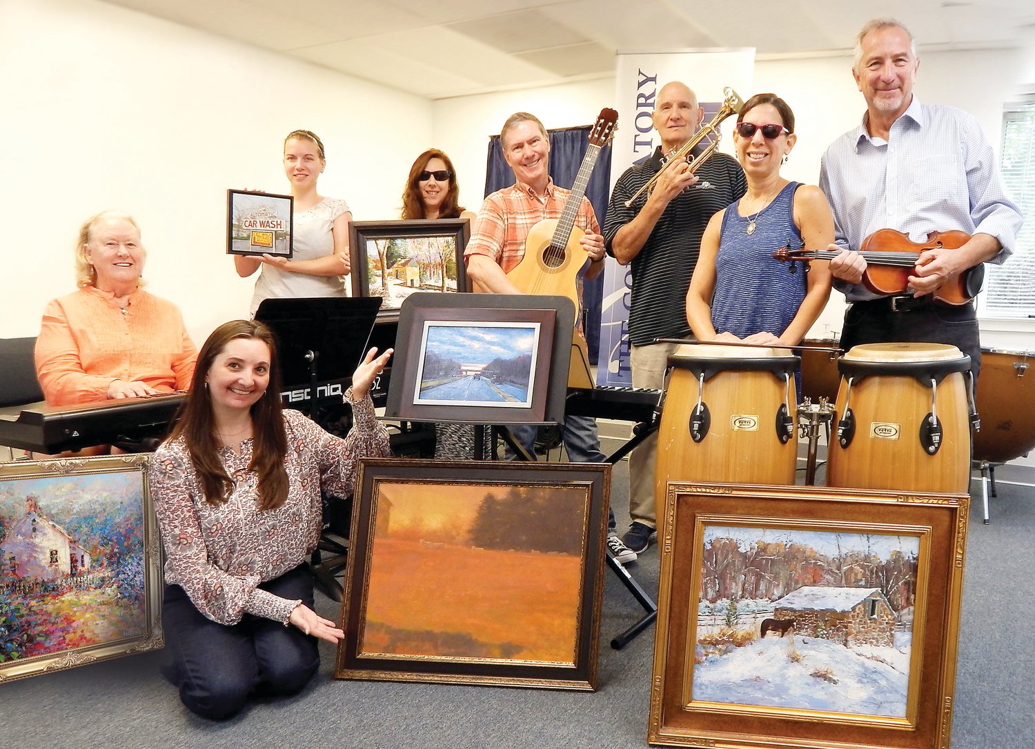 Seated from left are artist Betty Minnucci and Executive Director Rachael Gallagher. Standing from left are Program Manager Casey Bonner, Operations Manager Melanie Boyd, artist George Thompson, show treasurer Mike Minnucci, and artists Emily Thompson and Jas Szygiel.