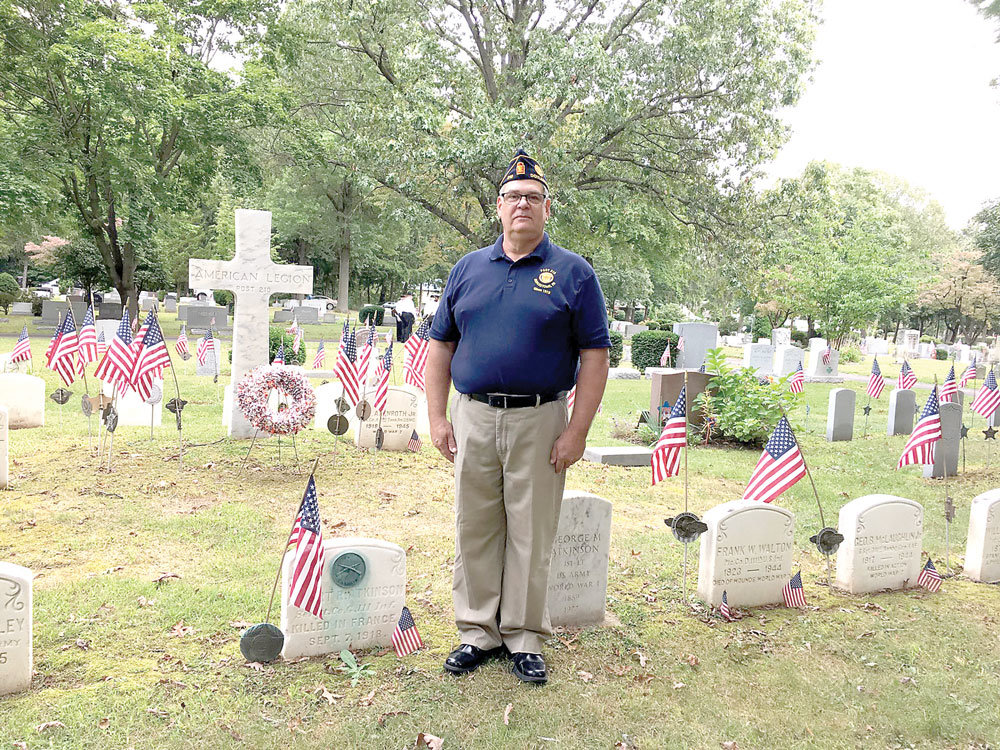 Chris Suessenguth, incoming commander of the Albert R. Atkinson Jr. American Legion Post 210 in Doylestown, stands by Atkinson’s grave. Members of the post and other community leaders commemorated the 101st anniversary of Atkinson’s death at his gravesite in Doylestown Cemetery. Photograph by Freda R. Savana.