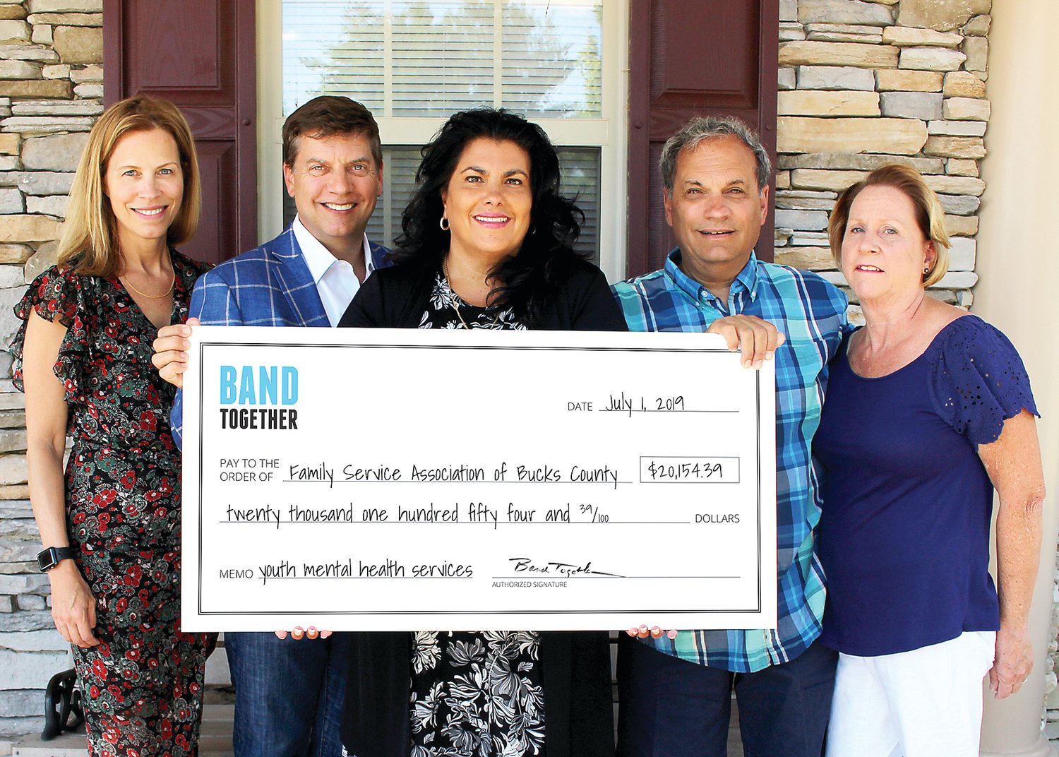 Heidi Hubert and Jeff Perkins; Dina Della Ducata, Family Service CEO; and Cliff and Linda Davis at a check presentation at Family Service’s Langhorne office