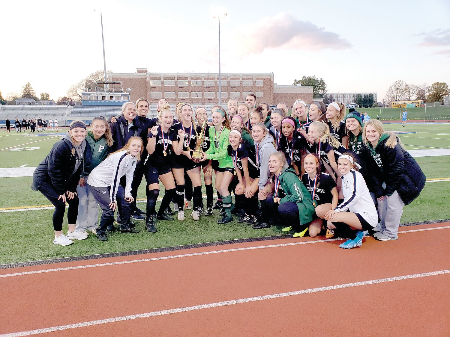 The Pennridge Rams pose with the District One Class 4A trophy. Photograph by Karen Sangillo .