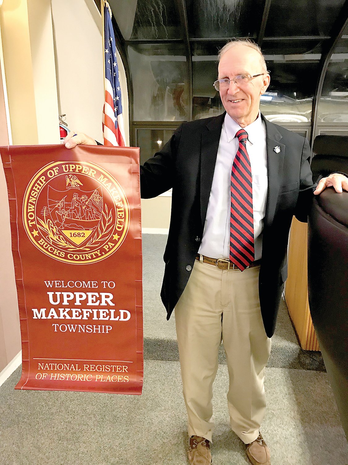 Upper Makefield Township Manager David Nyman displays one of the proposed streetscape banners for Washington Crossing. Photograph by Chris Ruvo.