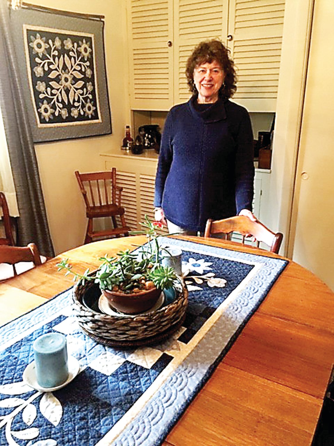 Janet Stoner with a quilted runner and a matching wall hanging in her Lahaska home. Photograph by Kathryn Finegan Clark.