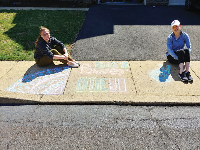 Kira Petri, left, and Rhiannon Dougherty of Solebury Township share encouragement with chalk art. Their message is “There’s power in pause.” Photograph by Stuart Lee Friedman.
