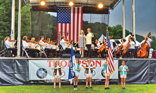 The 2019 Concert Under the Stars opened with an honor guard of Girl Scouts and a student singing “The Star Spangled Banner.” Mariusz Smolig is the conductor.