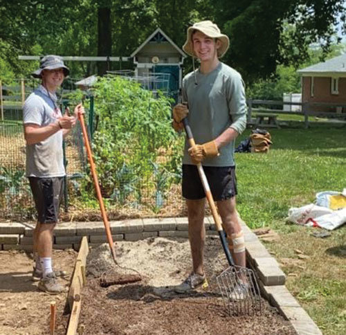 Mike Vanover, left, and Will Titus, Hopewell Helpers founder, building a garden.