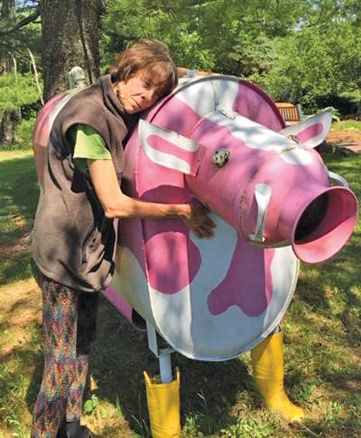 Dr. Julie Fagan of Haycock Township with the pink and white cow she made from an old oil can and some firefighters’ boots.
