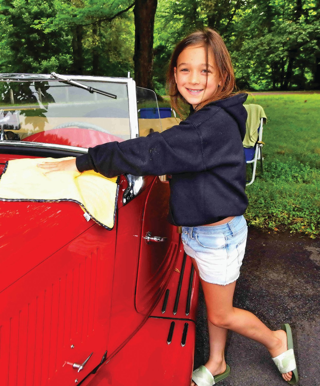 Emma Huttguist, 8, helps polish her father’s 1951 MG TD.