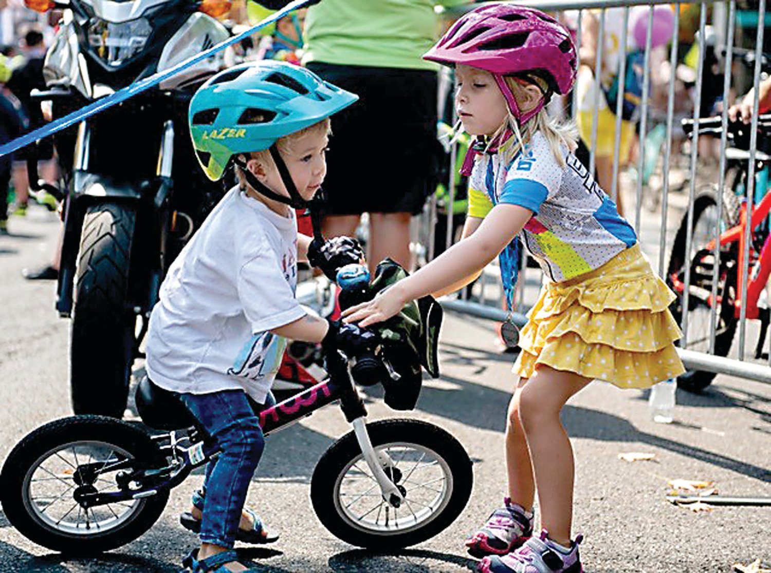 Scout Melby helps her little brother, Elliot Melby, after he fell off his bike.