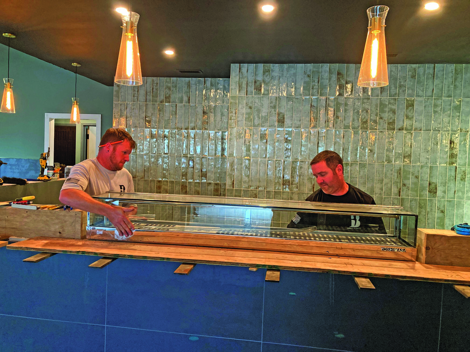 Jeff Burdette, right, and Casey Scritchfield of general contractor Burdette put a new sushi case in place at the new Kawaii Tori Sushi restaurant, set to open in mid-November in Yardley Borough.