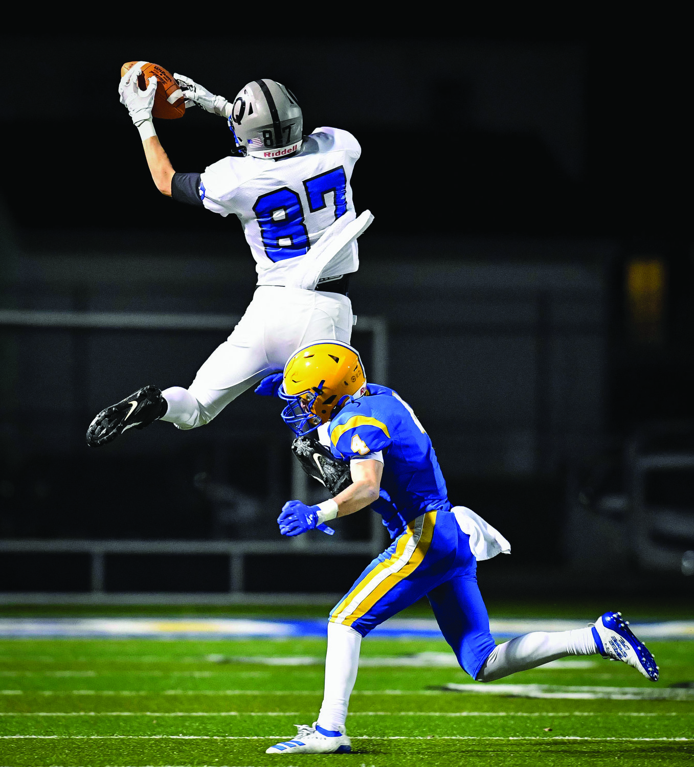 Quakertown’s Zach Fondl goes up to grab a pass from Will Steich in front of Downingtown East’s Duke Hetherington.