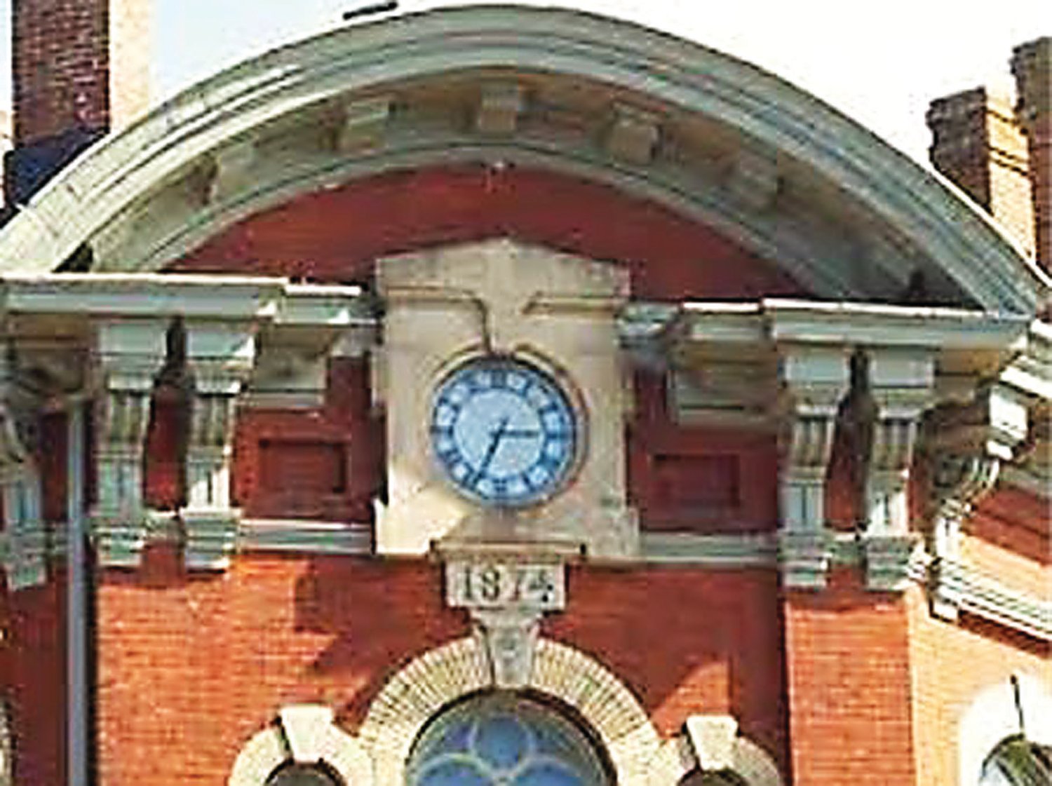 On the diagonal façade of Doylestown’s Lenape Hall, at the corner of State and Main Streets, is mounted a clock made by Louis Spellier. Immediately below the clock is a block, which bears the date of 1874.