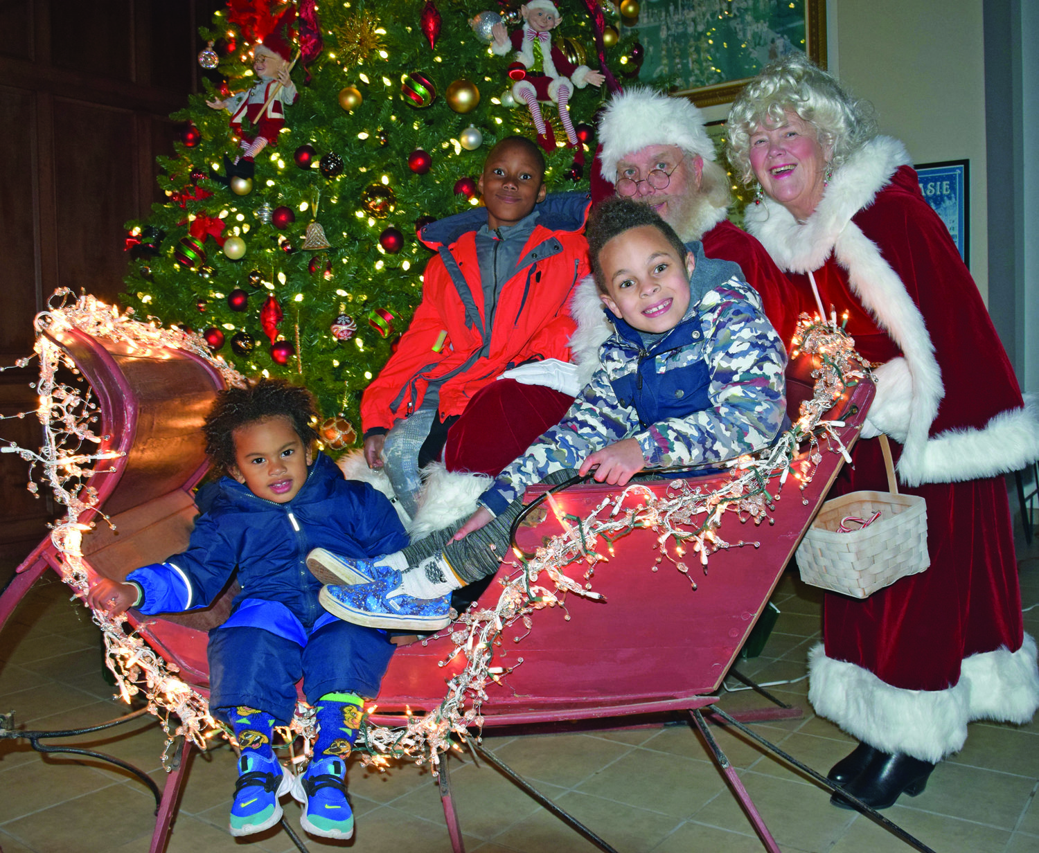 Kingston, 2, Arian 6, and Tyrese Smikle, 10, of Perkasie with Santa and Mrs. Claus.