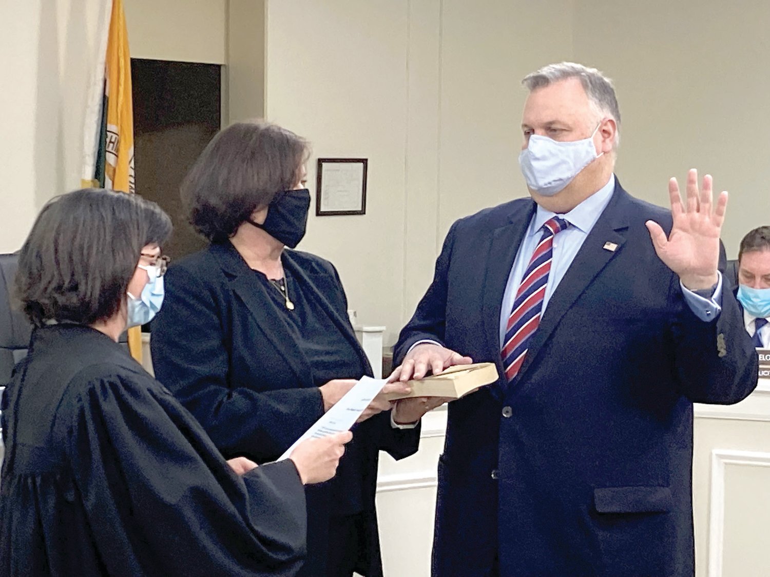 John Lewis is sworn in to a second six-year term as Lower Makefield Township supervisor at the Jan. 3 reorganization meeting as District Judge Corryn Kronnagel, left, administers the oath of office and Lewis’ wife Joanne, center, looks on.