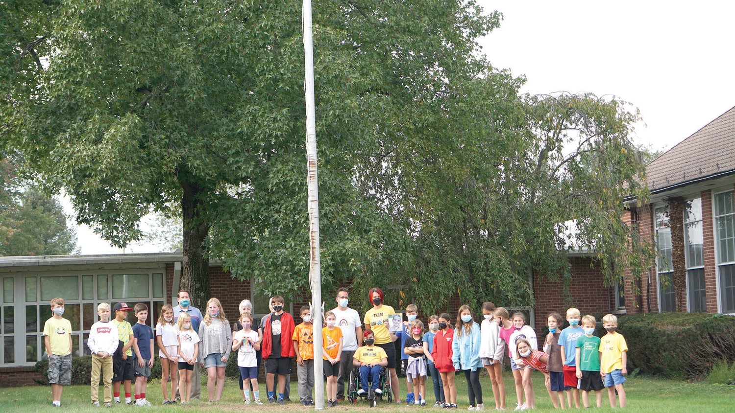 Kutz Elementary students and members of Dominic Liples’ family gather around the flagpole, where daffodil bulbs were planted in memory of Dominic, who passed away from brain cancer in 2016.