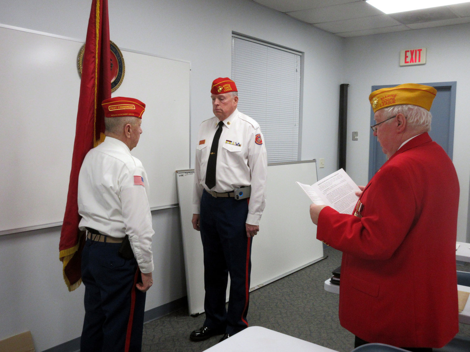 Outgoing Commandant Neil Clark Sr., left, and new Commandant Mike Clark, right, who is being sworn in by District 2 Vice Commandant Gene Irvin.