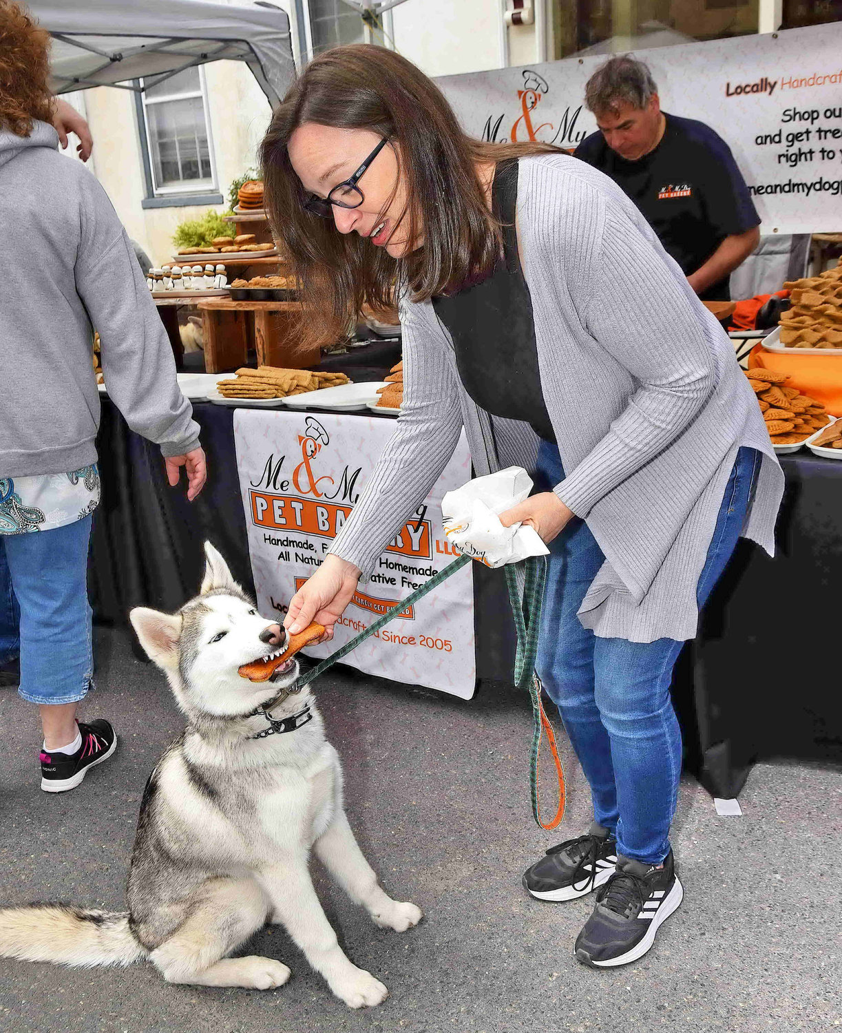 Erica Kalinowski feeds Echo, a Siberian husky, doggie treats from The Pet Bakery.