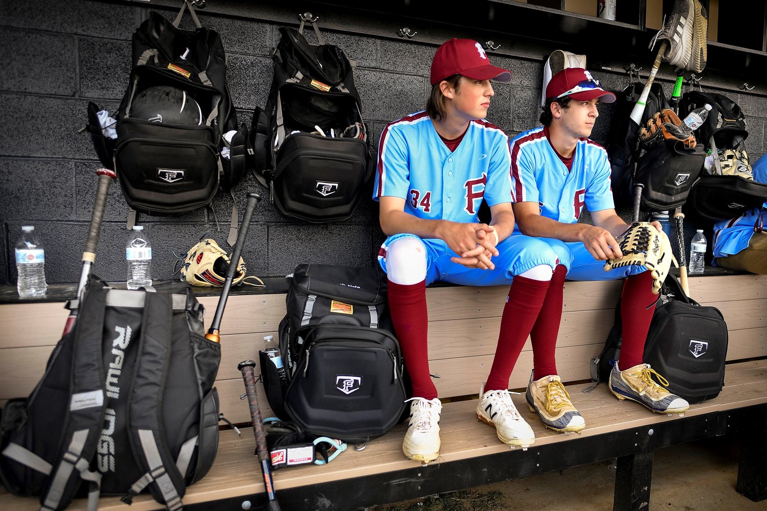 Faith starting pitcher Brody Harp sits next to Nathan Spicer before the start of the game.