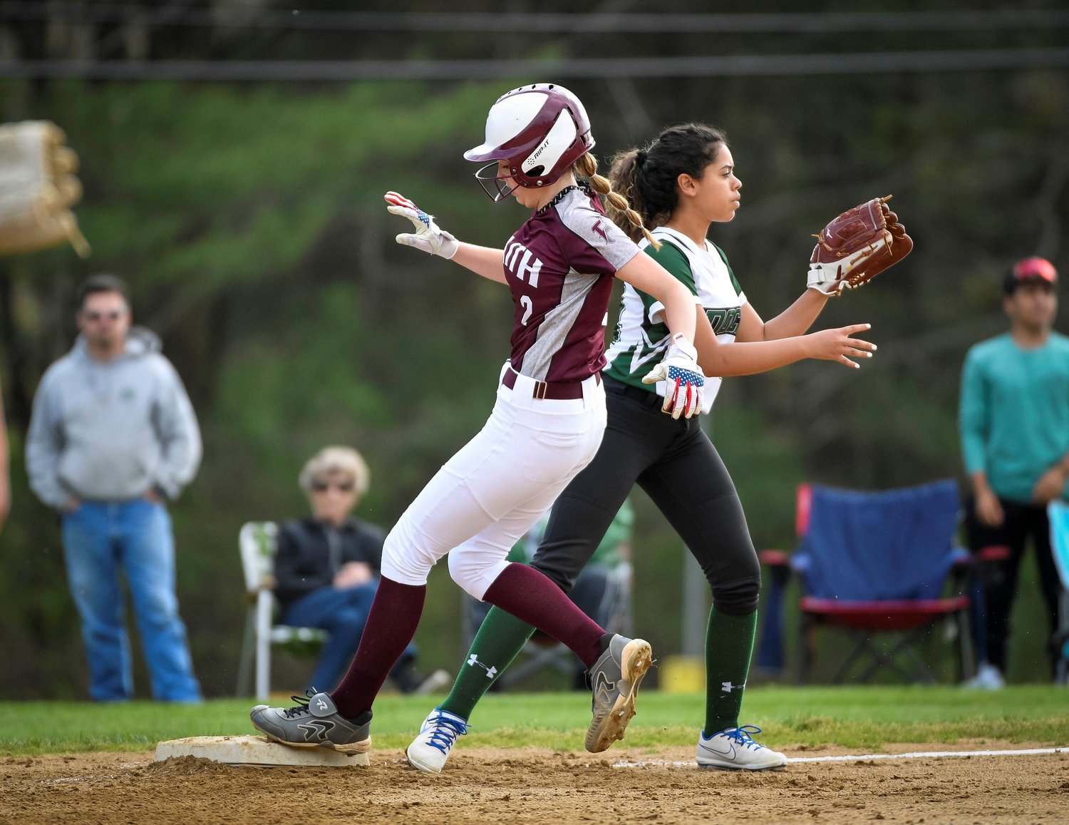 Faith’s Kamryn Pepkowski beats the throw in front of Dock’s Lianna Vargas for a third inning triple.