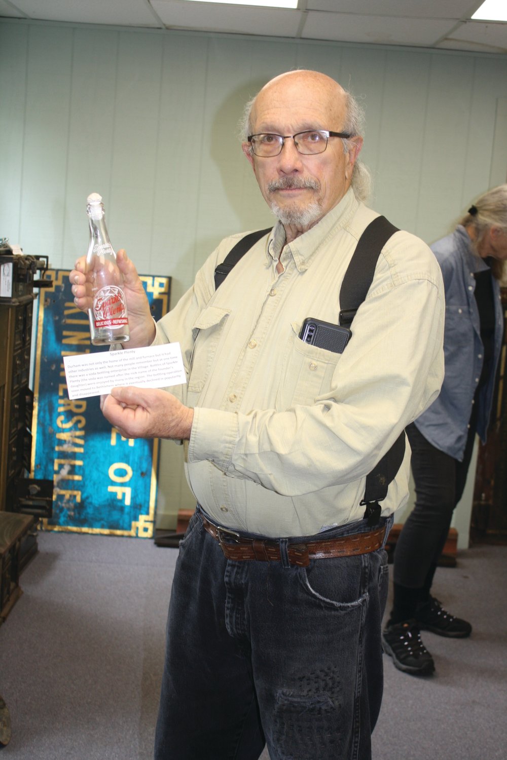 David Oleksa, president of the Durham Historical Society, displays a Sparkle Plenty soda bottle. The beverage was once made and bottled in Durham.