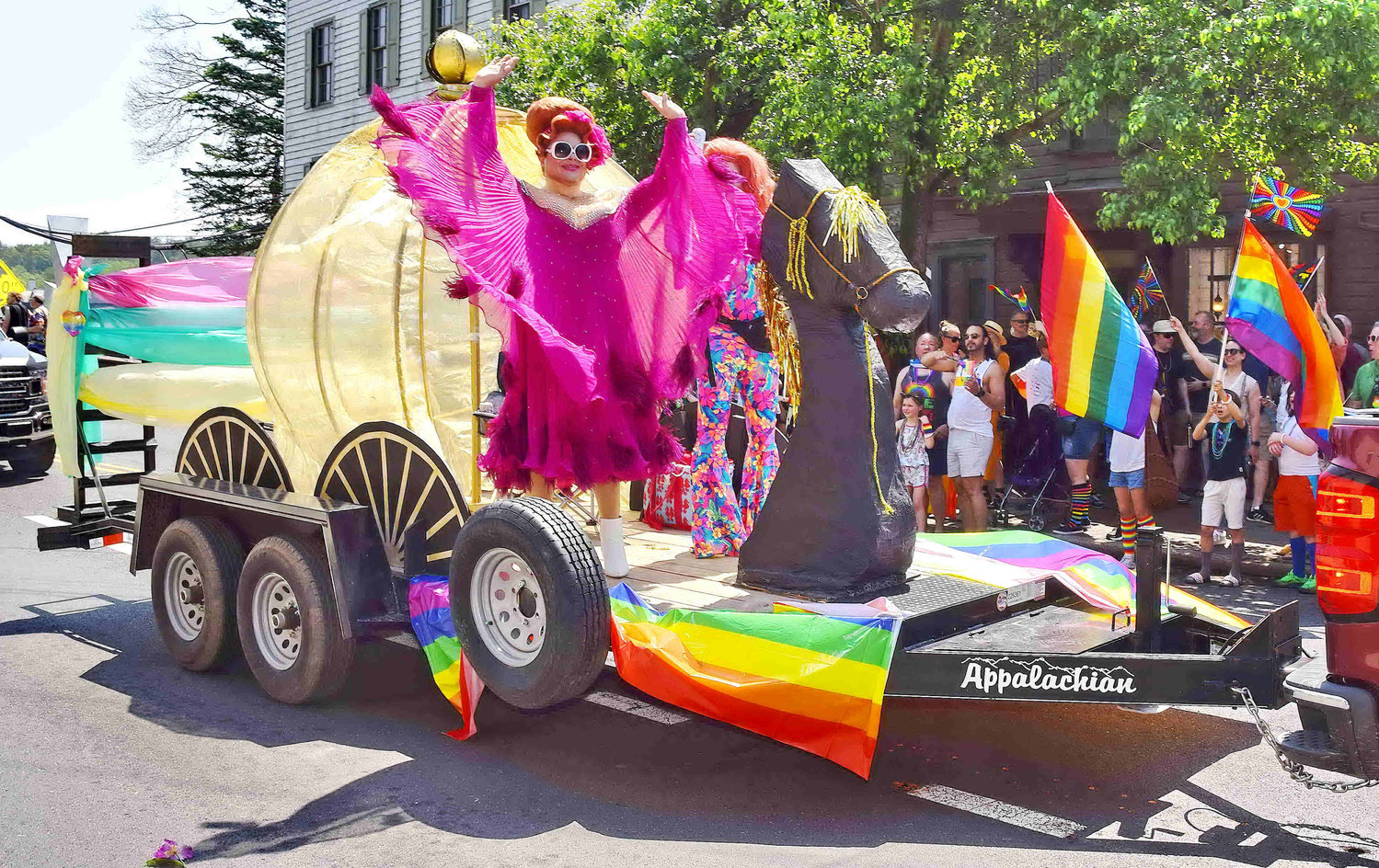 A Pride Parade participant waves to the crowd.