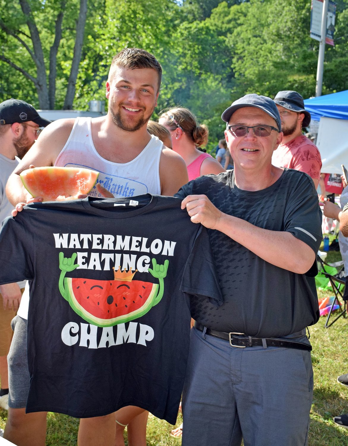 Chris Adams won first place and received a Watermelon Eating Champ T-shirt from the Rev. Jeff Wargo of St. Stephen’s UCC, the game sponsor.