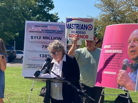 Council Rock School Board member Mariann McKee criticizes gubernatorial candidate Doug Mastriano’s education plan as Solebury Township Republican Committeeman Keith Wolff holds up a Mastriano for governor sign during a Thursday, Sept. 15 press conference in Newtown Borough.