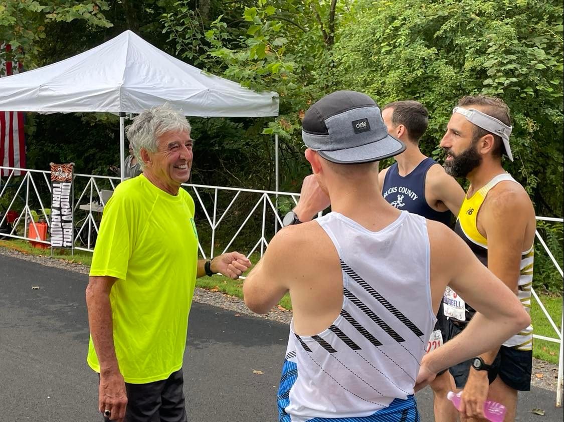 Frank Shorter, left, winner of the 1972 Olympic men’s marathon gold medal at Munich, Germany, chats with runners prior to the start of the “Chasing the Unicorn’’ Marathon at Washington Crossing Historic Park.