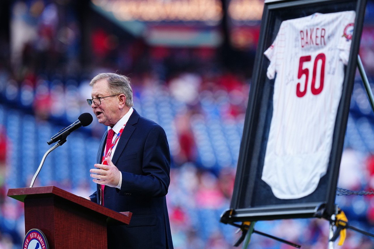 Dan Baker delivers an acceptance speech on the field at Citizens Bank Park after being presented with a team signed and framed Phillies jersey and bronze microphone for 50 years of service as the team’s PA announcer.