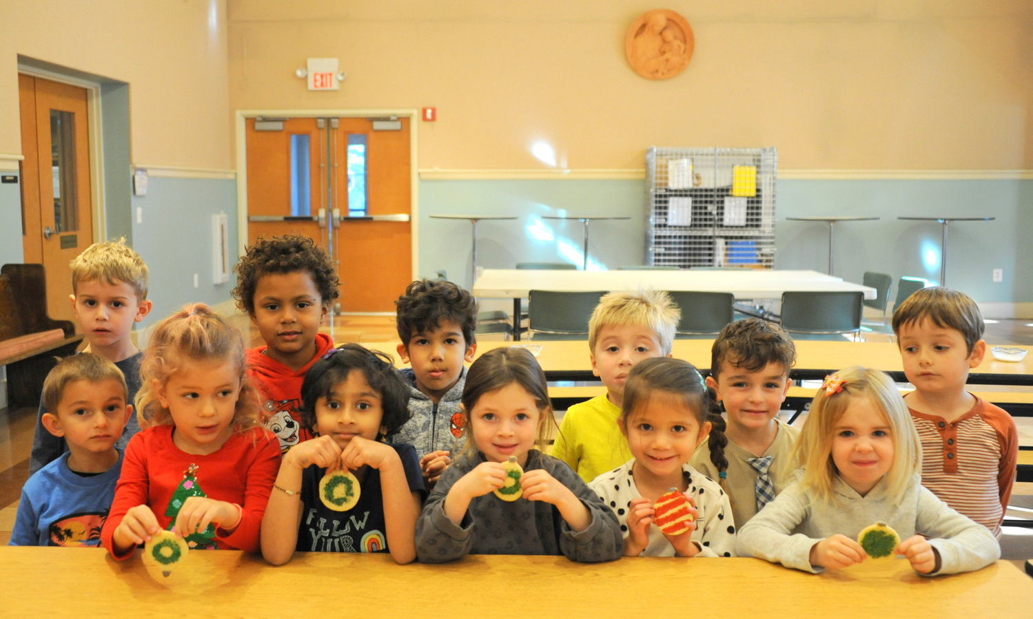 Little kids pose with their cookies for a picture during the Trinity Church Solebury annual cookie bake. At the winterholiday season, for 75 years, church volunteers have mixed, cut and baked the holiday cookies.