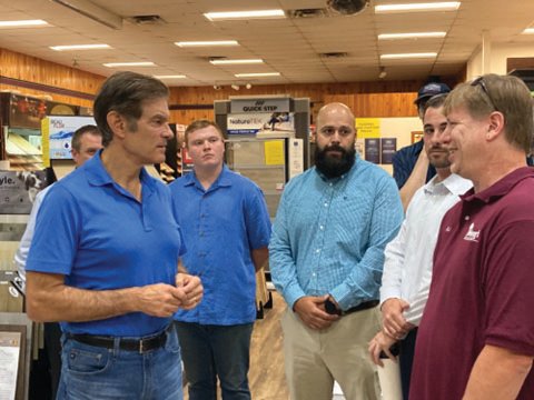 Republican U.S. Senate candidate Dr. Mehmet Oz, left, talks to Purchasing Manager D.J. Stahley, right, and other employees and managers during a campaign stop at Wehrung’s Lumber and Home Center in Ottsville.